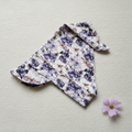 Floral baby hat on knitted fabric with lilac flower